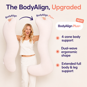 A woman stands between two large pale pink body pillows on a light beige background, with promotional text reading 'The BodyAlign, Upgraded' and 'BodyAlign Plus+'. The pillows are shown as the product, and the woman is included in the presentation, so this is Lifestyle rather than Product/Packaging.